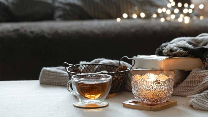 Sohva, kuppi teetä ja kynttilä koti-iltaa varten